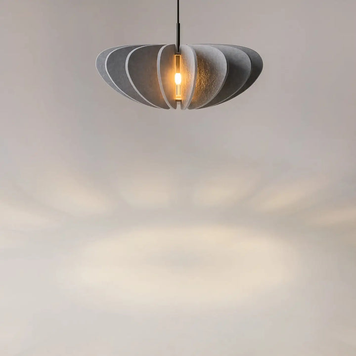 Suspension luminaire cambio coupole en aluminium noir avec pendentif gris à couches et lumière chaude au-dessus d’une table