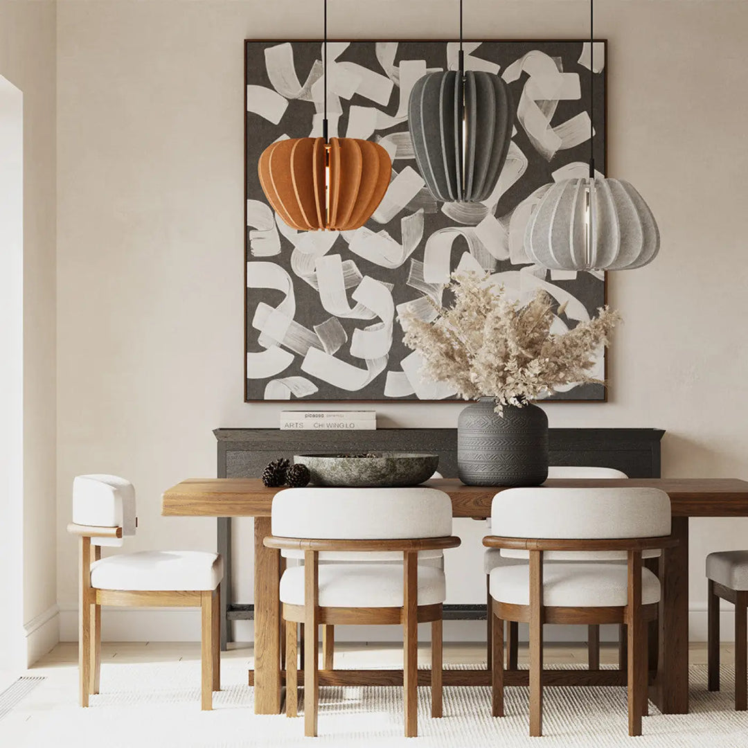Suspension luminaire cambio coupole en aluminium noir suspendue au-dessus d’une table en bois avec chaises blanches et vase gris