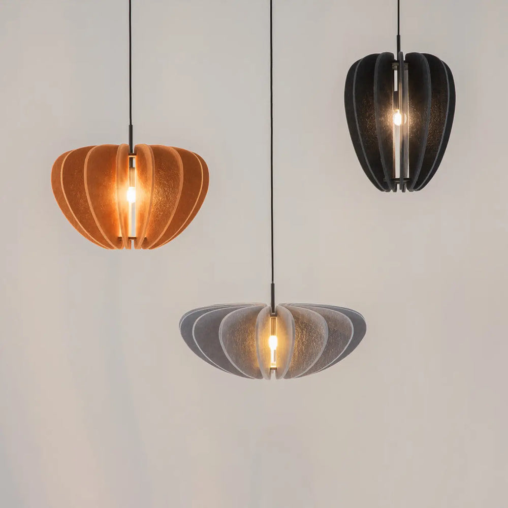 Suspension luminaire cambio coupole avec trois luminaires en aluminium noir au-dessus d’une table en ambre, noir mat et gris translucide