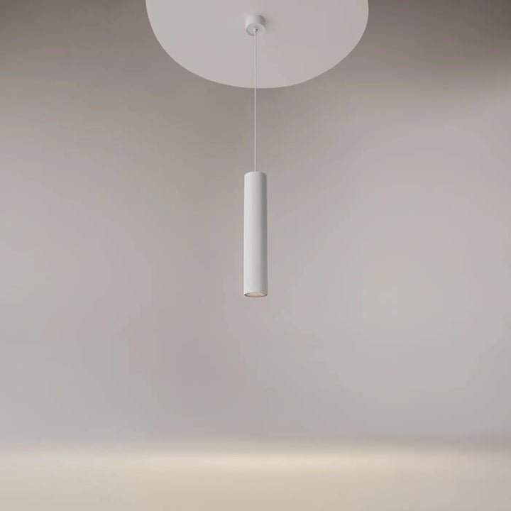 Suspension artisan en cylindre blanc minimaliste au-dessus d’une table avec un design moderne et épuré
