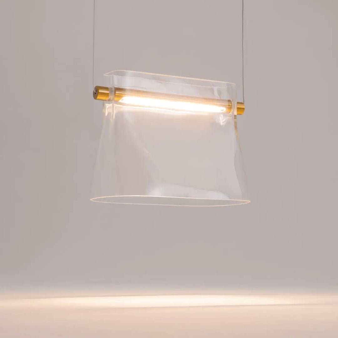 Suspension cabaret en verre transparent avec fixations dorées pour éclairage au-dessus d’une table moderne