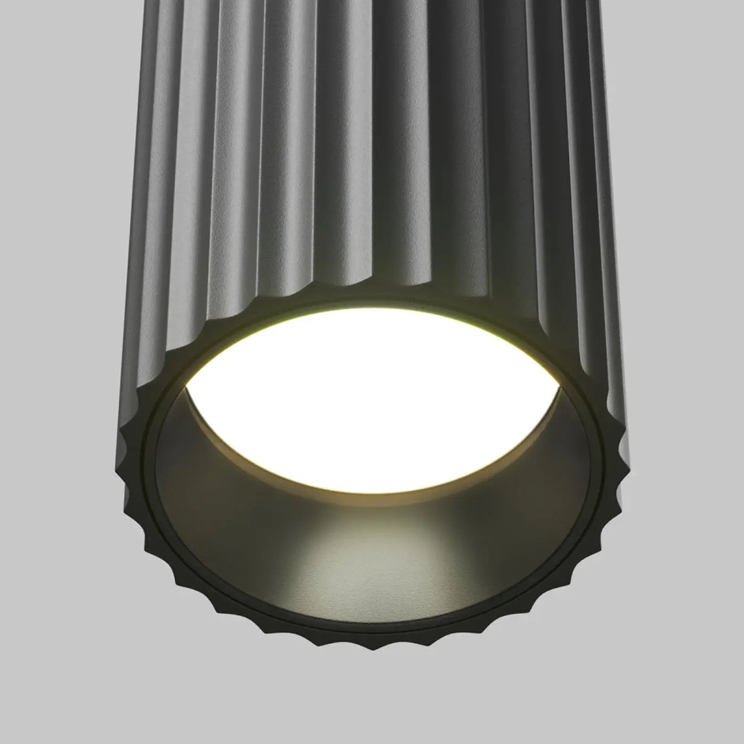 Suspension luminaire calipso tube gris foncé cylindrique à rainures verticales avec bord festonné au-dessus d’un îlot