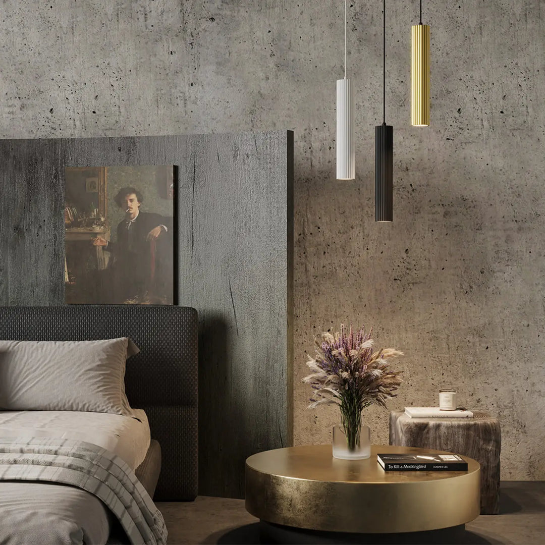 Suspension luminaire calipso tube or doré cylindrique avec texture rainurée suspendue au-dessus d’un îlot