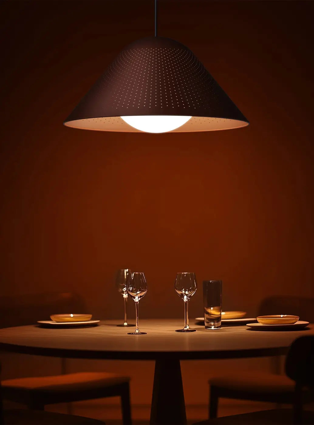 Suspension Bola Bell orange à tige noire dans un intérieur