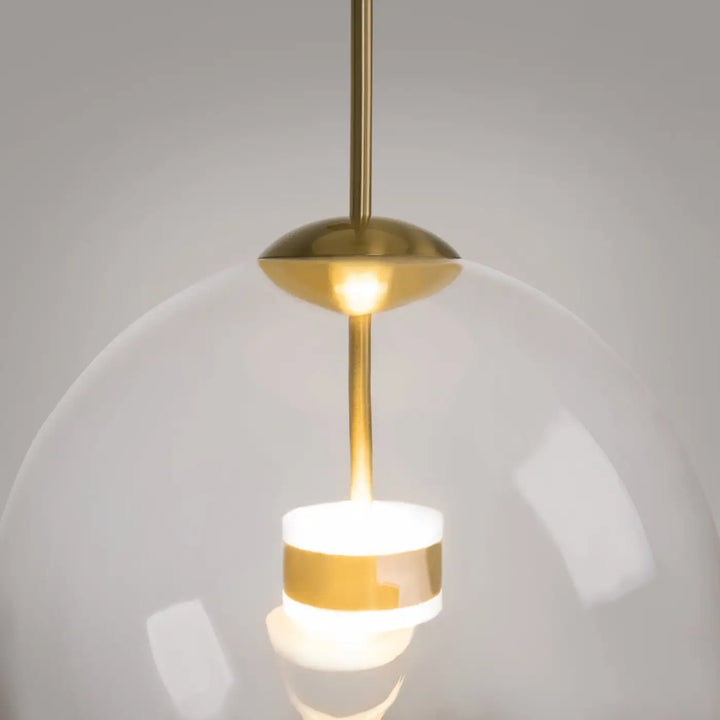 Suspension cometa avec verre soufflé en globe transparent et bande dorée, idéale au-dessus d’une table moderne