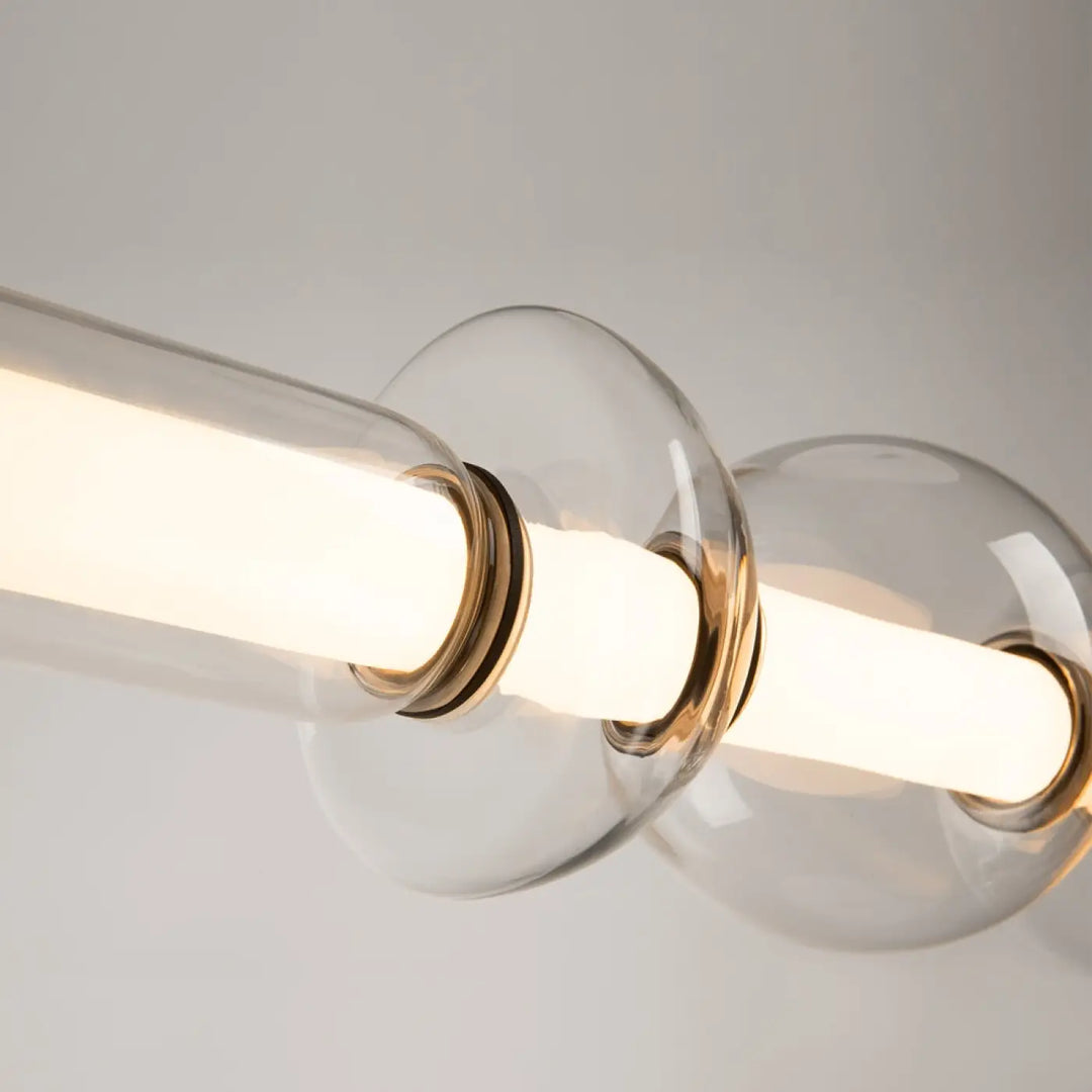 Suspension luminaire cosmo linéaire en verre transparent avec accents en laiton chaud et led linéaire intégrée