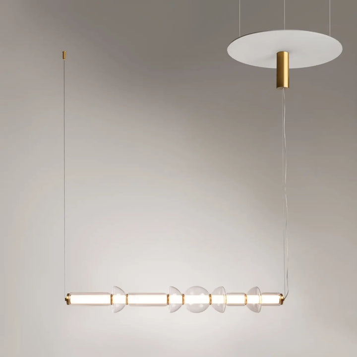 Suspension luminaire cosmo linéaire avec led linéaire, verre transparent et verre strié, finition laiton et câbles fins