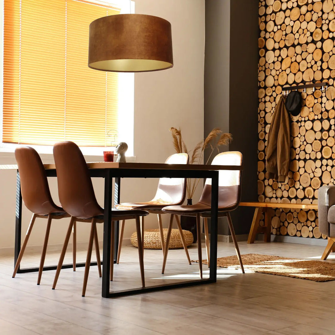 Brown leather dining chairs with slender wooden legs and black metal frames complementing suspension cylindrique caramel sapporte doré luminaires décoratifs