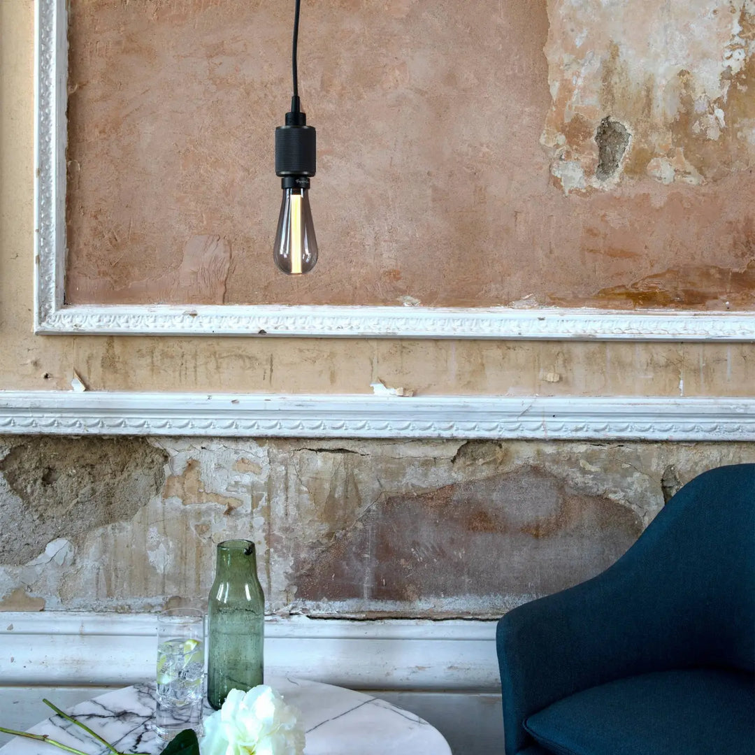 Suspension Heavy Metal à gravure quadrillée en bronze fumé dans un intérieur #couleur_gris