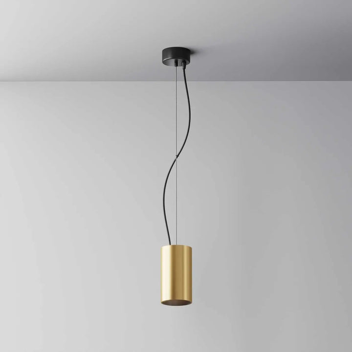 Suspension efir cylindre doré avec design minimaliste en métal suspendue par cordon noir au-dessus d’un îlot