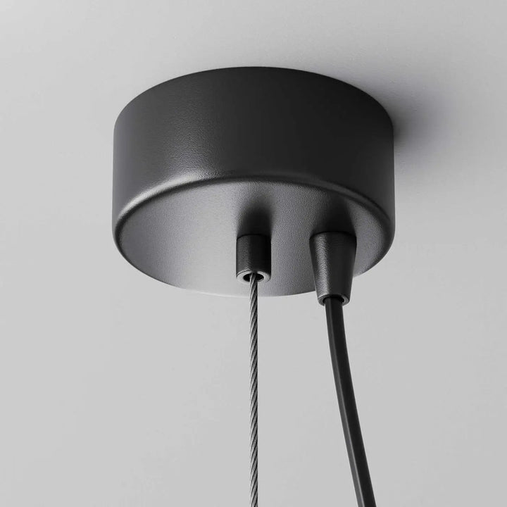 Suspension efir cylindre noire mate avec base cylindrique et câbles en acier et noir, idéale au-dessus d’un îlot
