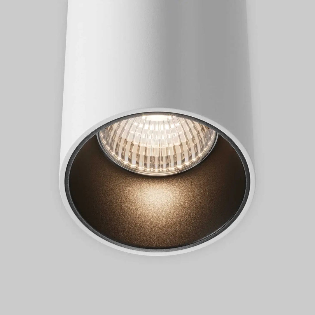 Projecteur cylindrique blanc suspension efir avec réflecteur intérieur noir mat et lentille en verre au-dessus d’un îlot