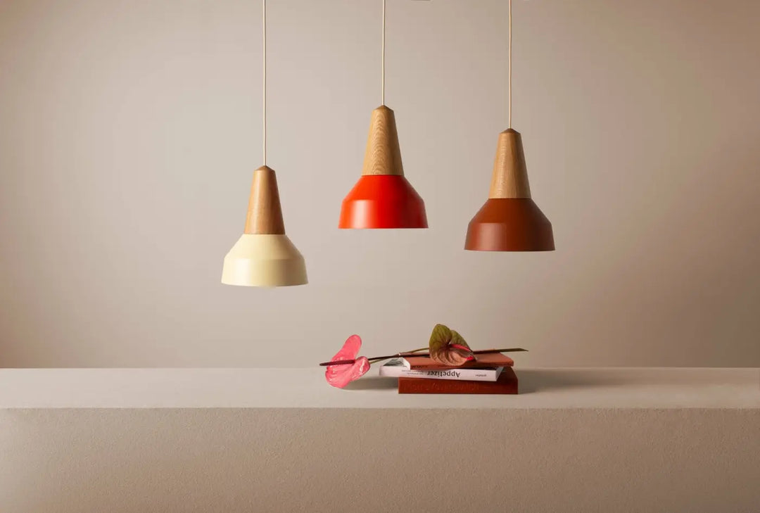 Suspension Eikon Basic en chêne et ambré au-dessus d'une table #couleur_marron