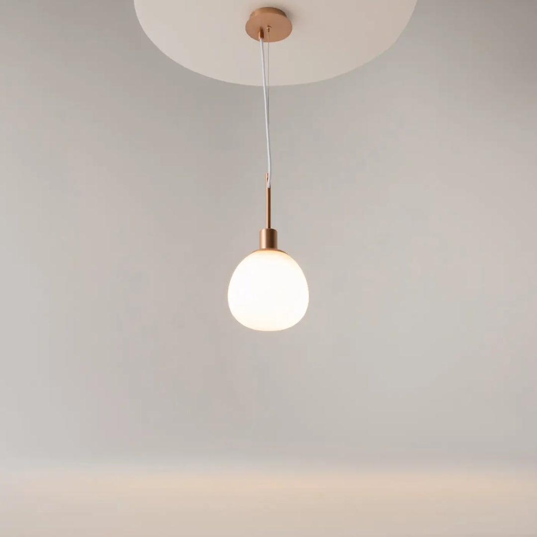 Suspension luminaire erich globe avec globe en verre soufflé blanc mat et accents cuivre ton art déco lumière douce