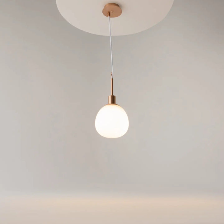 Suspension luminaire erich globe avec globe en verre soufflé blanc mat et accents cuivre ton art déco lumière douce