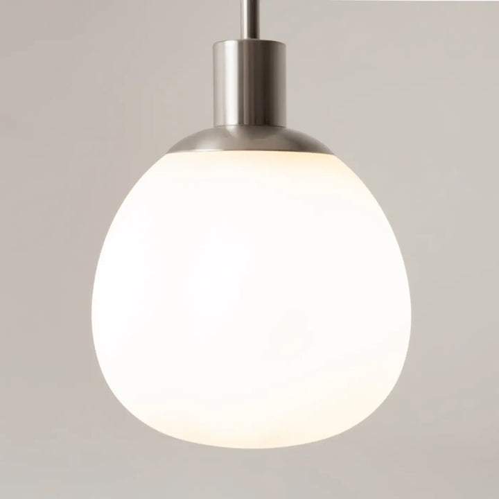 Suspension luminaire erich avec globe en verre soufflé blanc mat et finition acier brossé pour une lumière douce art déco