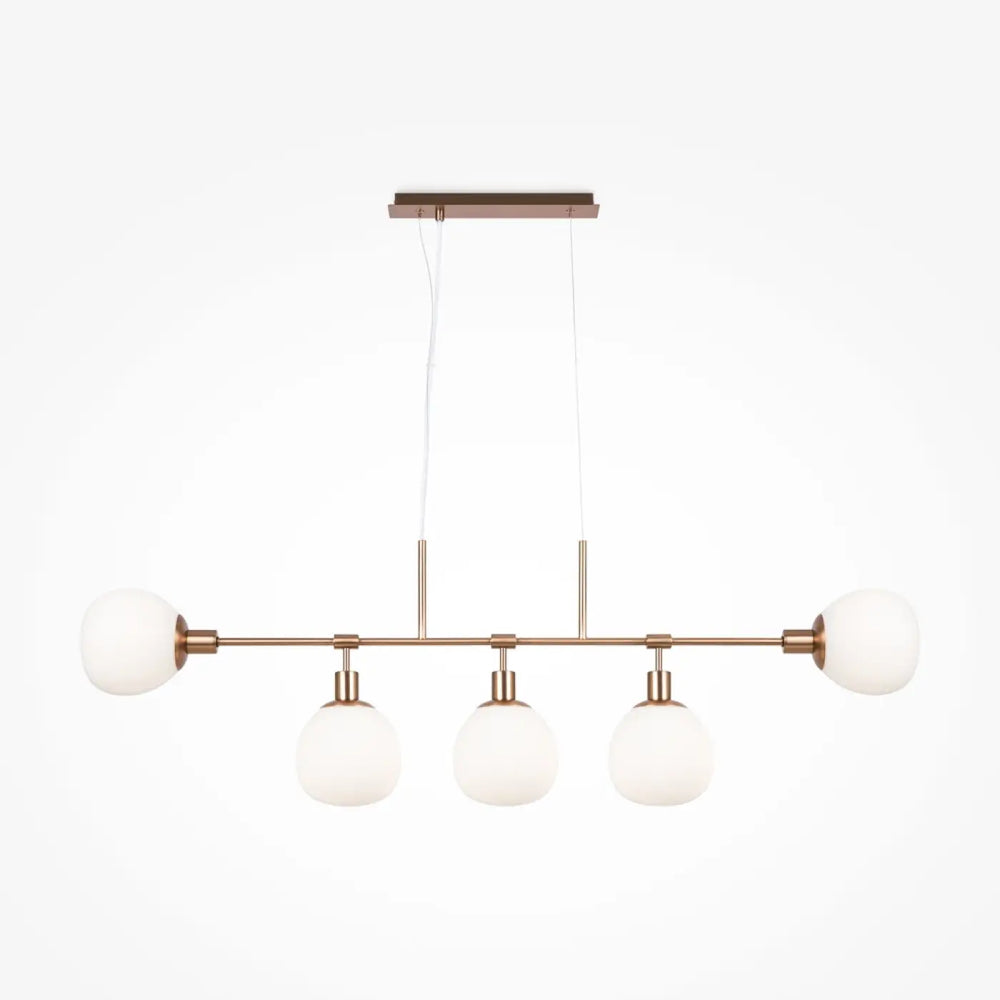 Suspension luminaire erich linéaire en cuivre moderne avec quatre globes en verre givré au-dessus d’une table