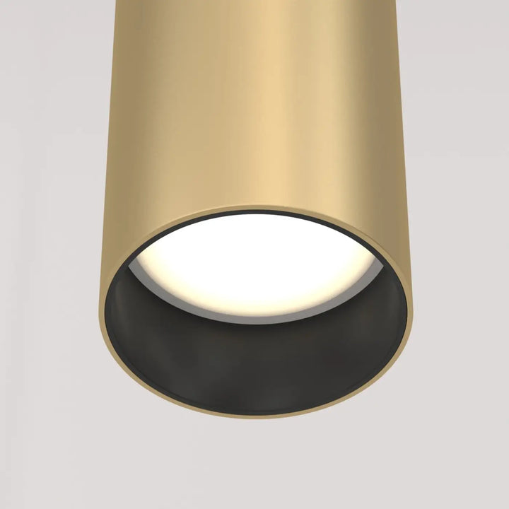 Suspension focus cylindre au-dessus d’un îlot avec tube fin en métal doré brossé et intérieur noir élégant