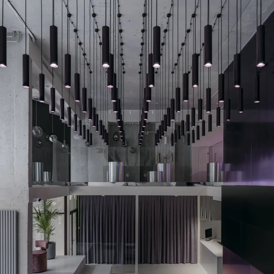 Suspension luminaire focus cylindre en tube fin noir suspendue au-dessus d’un îlot dans un style minimaliste moderne