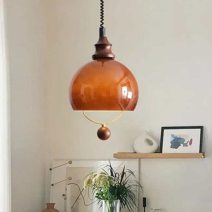 Suspension globe ambrée avec détail doré et boule décorative

