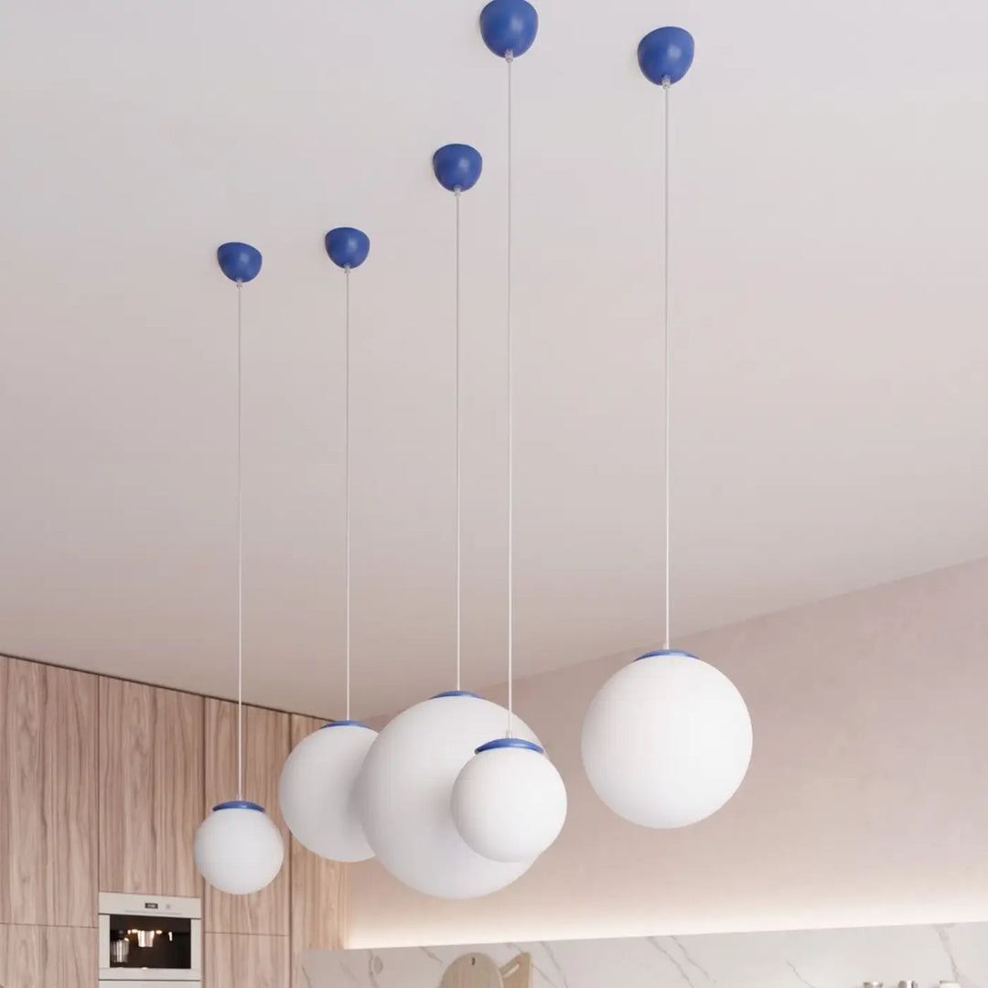 Suspension Ugo à globe en verre blanc et monture outremer dans un intérieur contemporain