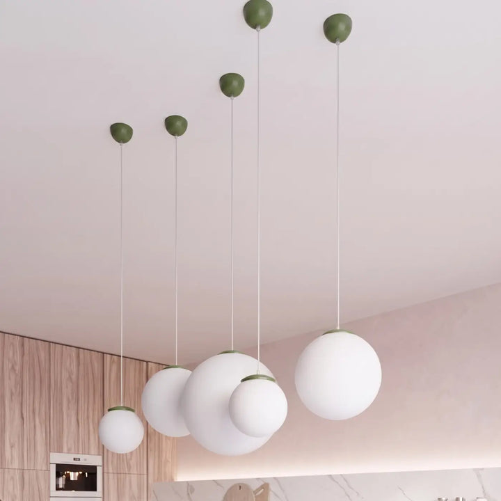 Suspension Ugo à globe en verre blanc et monture vert olive dans un intérieur contemporain