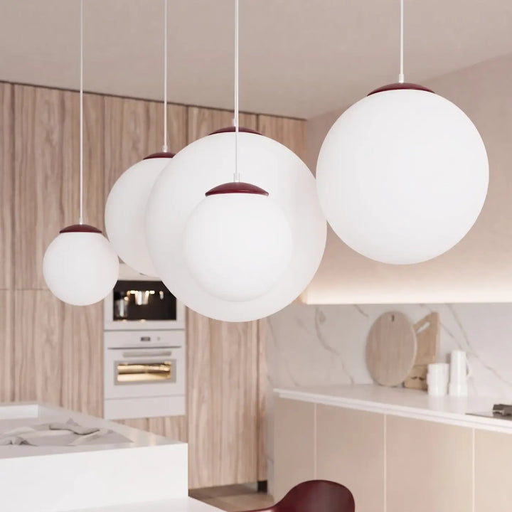 Suspension Ugo à globe en verre blanc et monture bordeaux dans un intérieur contemporain