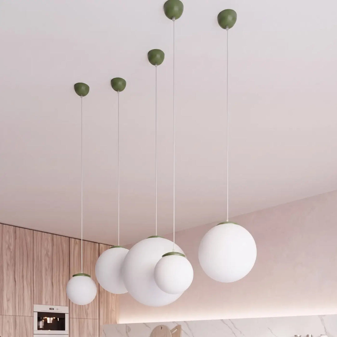 Suspension Ugo à globe en verre blanc et monture vert olive dans un intérieur contemporain