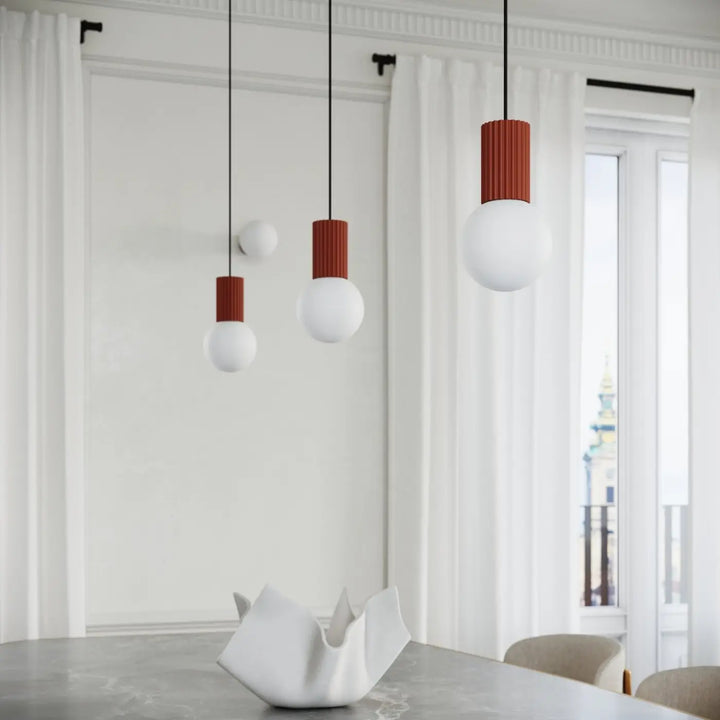 Suspension Luminaire ocre rouge allumée, vue rapprochée
