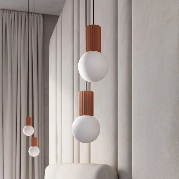 Suspension Luminaire ocre rouge allumée, vue rapprochée