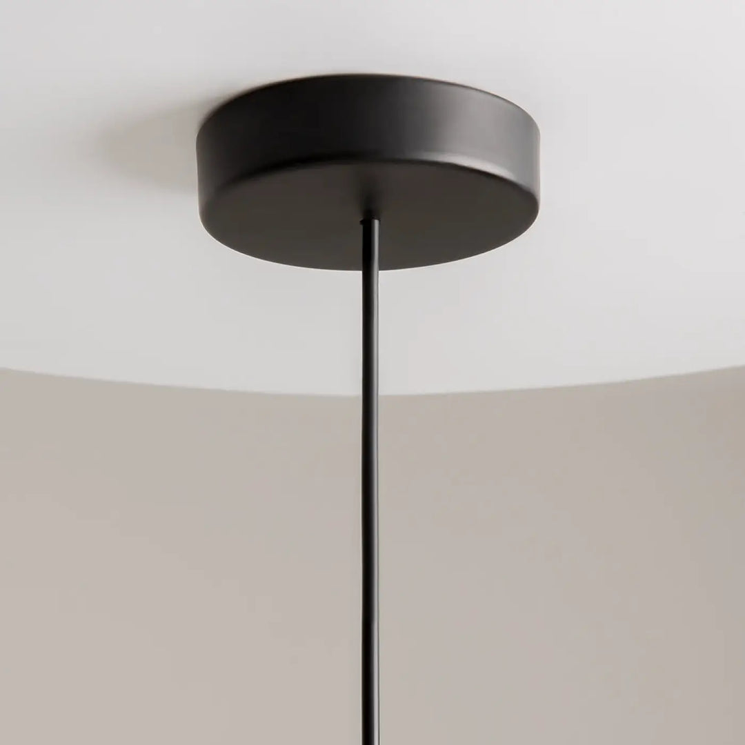 Suspension kyoto cylindre en finition mate noire avec base circulaire élégante et tige fine pour lumière douce
