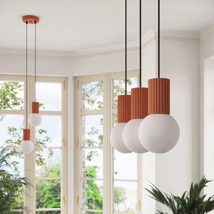 Suspension Luminaire ocre rouge allumée, vue rapprochée