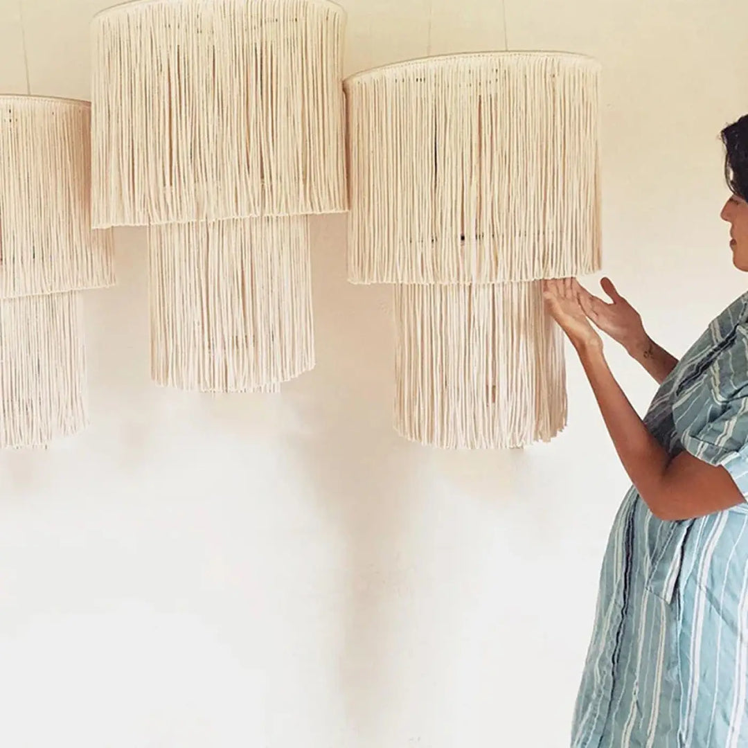 Suspension luminaire bohème hasley en macramé beige avec franges en matières naturelles et brins en cascade à étages