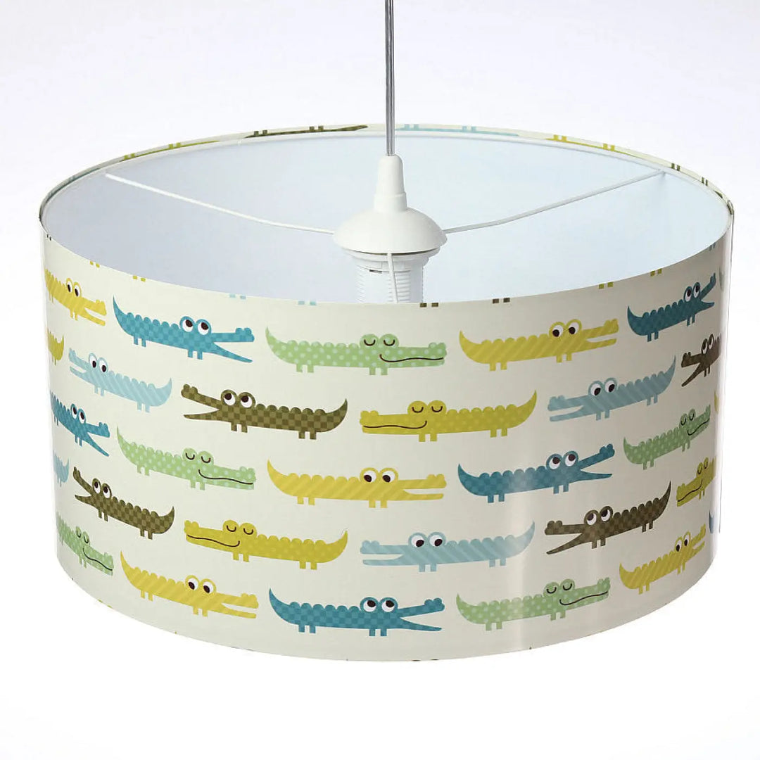 Suspension luminaire chambre avec abat-jour cylindrique motif crocodile apporte couleurs jaune bleu vert et marron sur fond écru