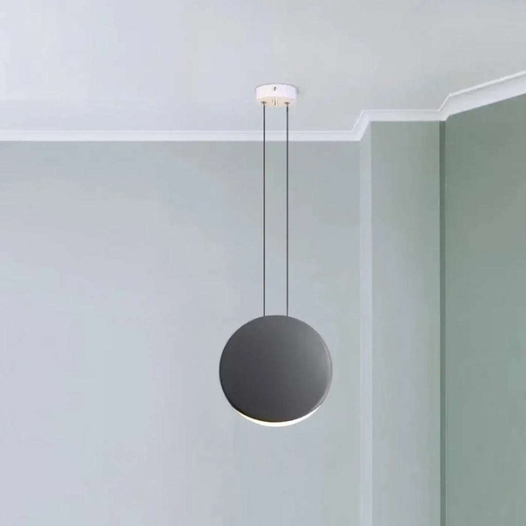 Suspension luminaire lunis avec abat-jour circulaire mat noir minimaliste suspendu par câbles fins au plafond blanc