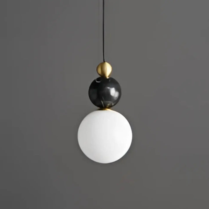 Suspension luminaire eluna avec design sphérique noir et blanc et accents en laiton pour un luminaire design élégant