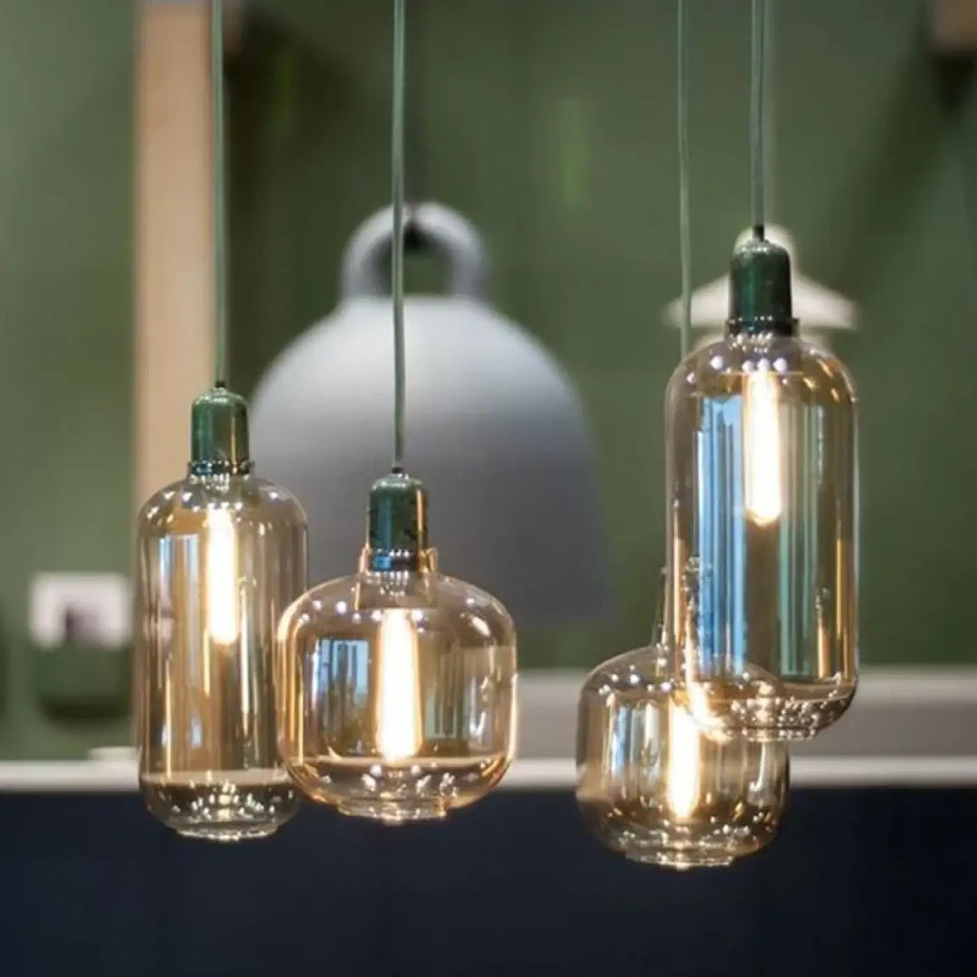 Suspension luminaire hyalis en verre teinté ambre avec formes arrondies et dessus métallique vert à filament visible