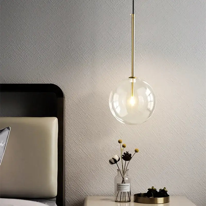 Suspension luminaire doré avec une boule en verre transparente

