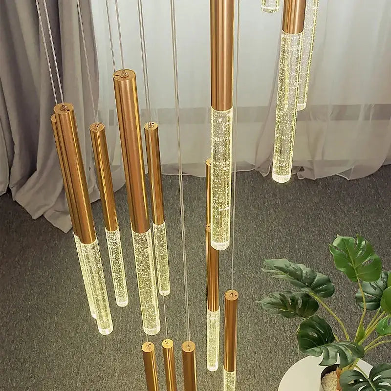 Suspension luminaire dorée avec une barre transparente pour escalier

