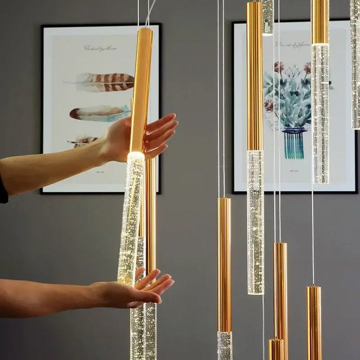 Suspension luminaire dorée avec une barre transparente pour escalier

