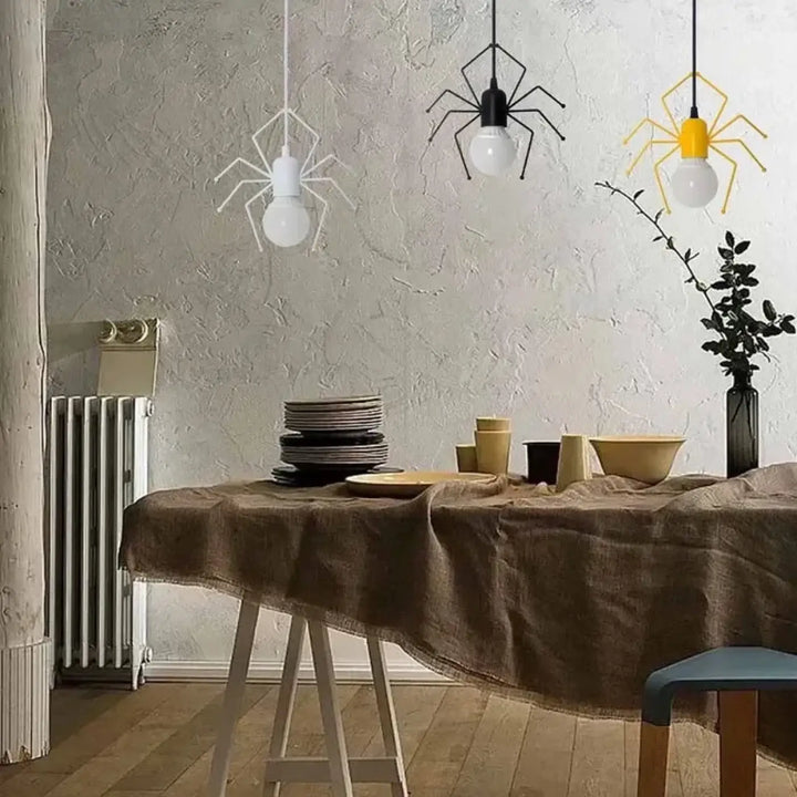 Suspension luminaire alako ludique avec trois cadres métalliques noirs blancs et jaunes en forme daraignée et ampoules apparentes