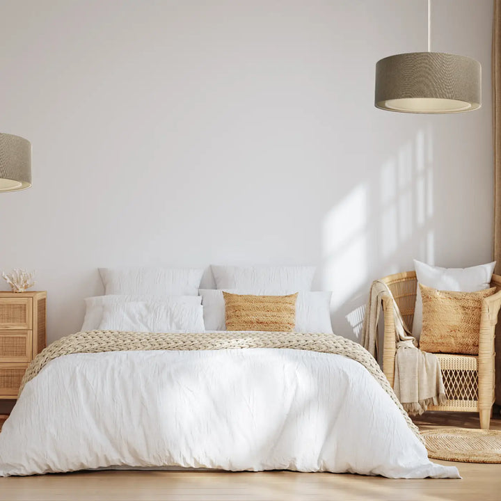 Suspension luminaire duo boho elegant marron sable sur un lit blanc avec plaid beige tissé texturé
