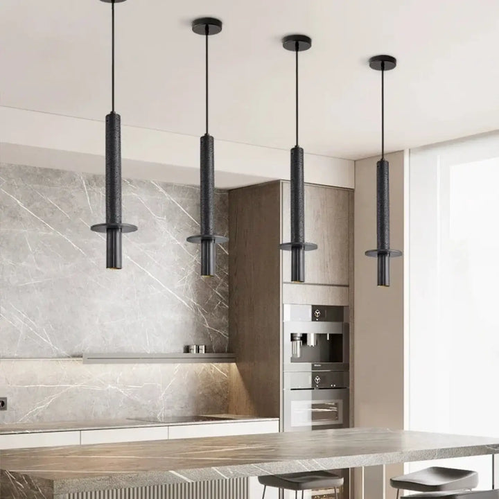 Quatre suspensions luminaire minimaliste alva noires cylindriques avec surface texturée en pierre naturelle pour décoration intérieure