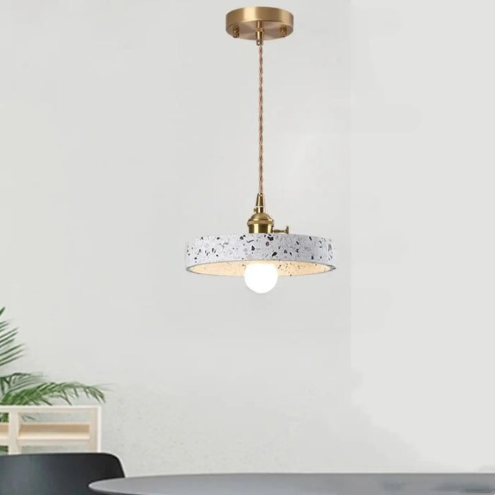 Suspension luminaire tos ca montre l’image d’un pendentif moderne avec abat-jour en terrazzo blanc et accents en laiton réglable