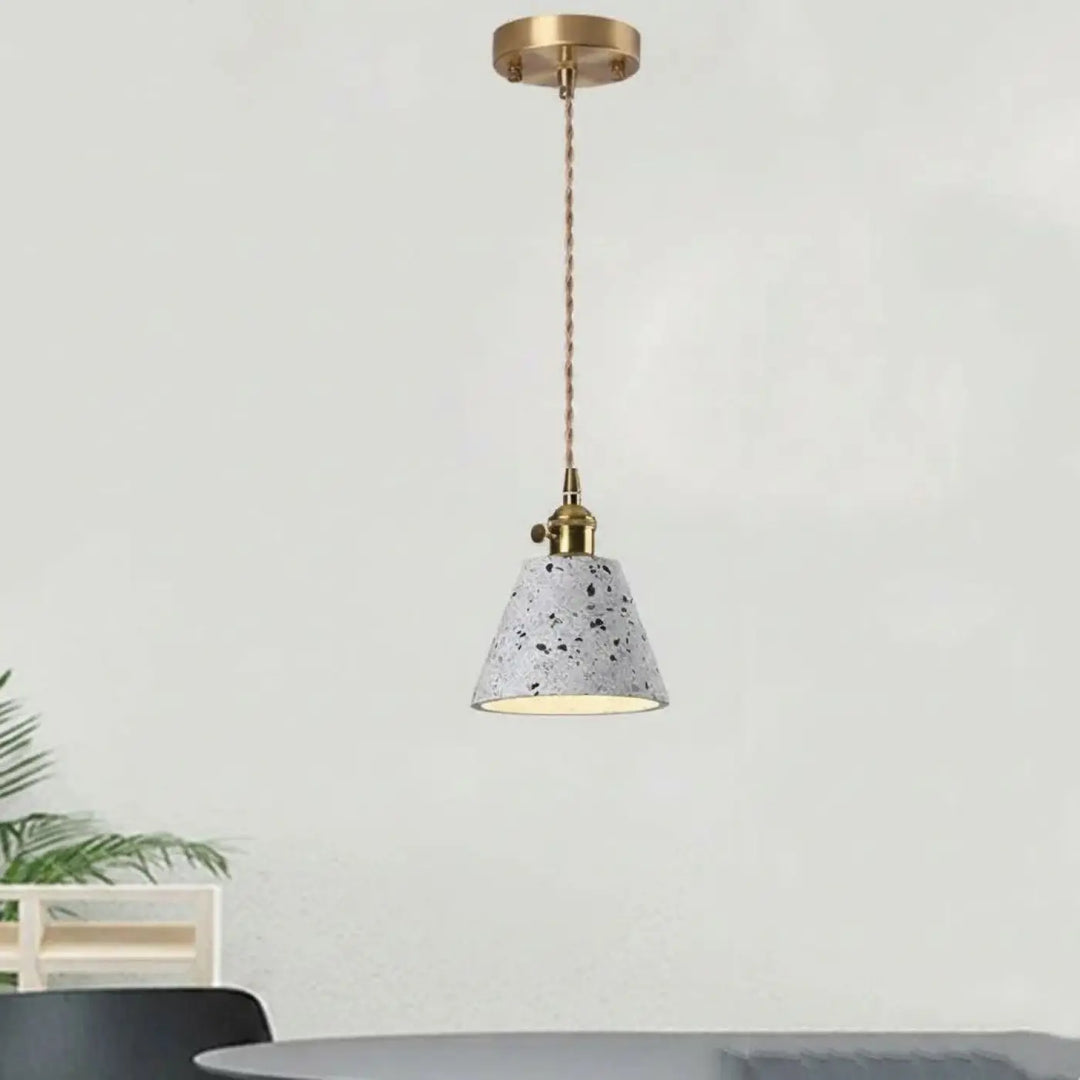 Montre l’image suspension luminaire tosça avec abat-jour en béton gris moucheté et accents en laiton chaîne cordon réglable