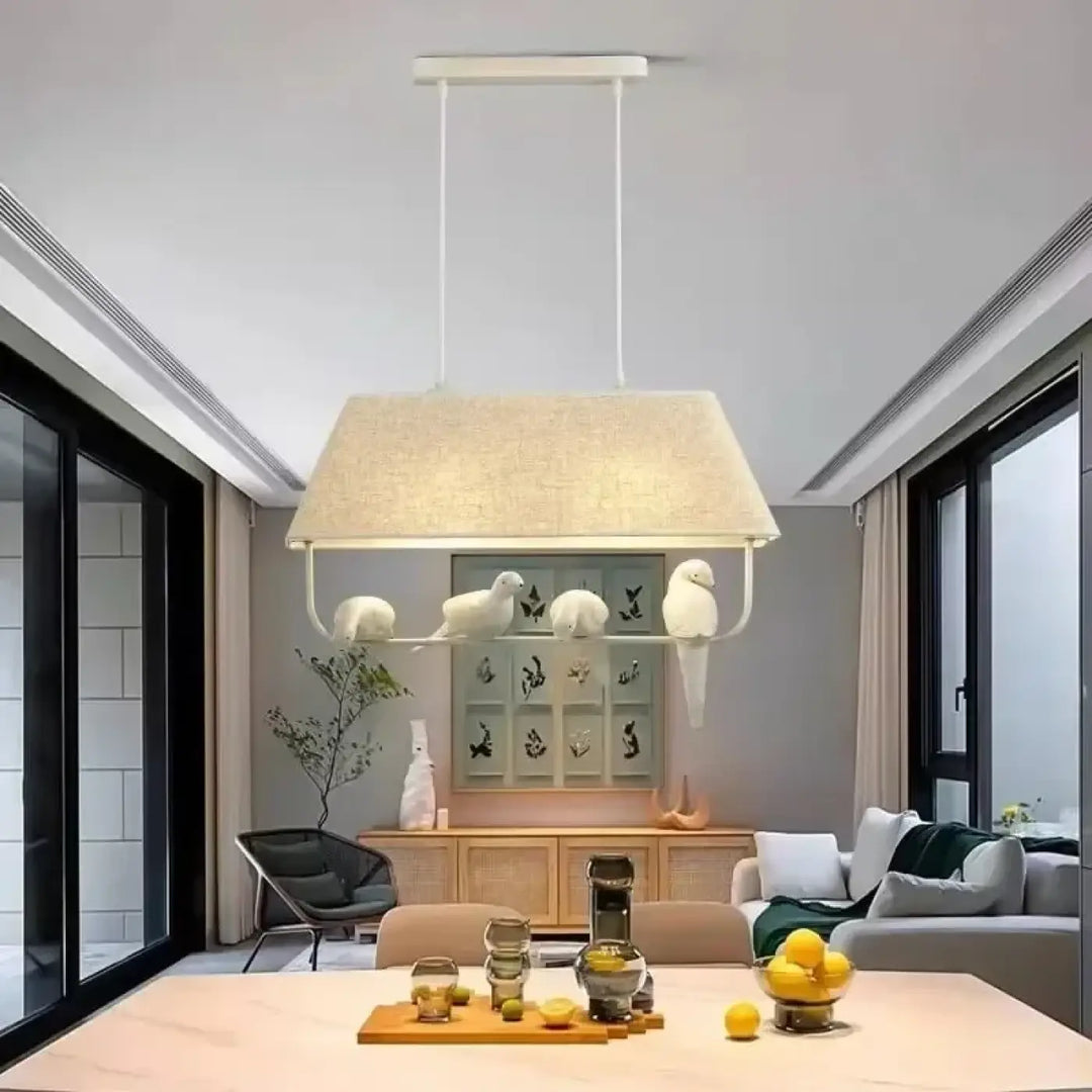 Suspension luminaire rectangulaire lumibird avec abat-jour en lin beige et cadre métal blanc ornée de quatre oiseaux sculptés blancs