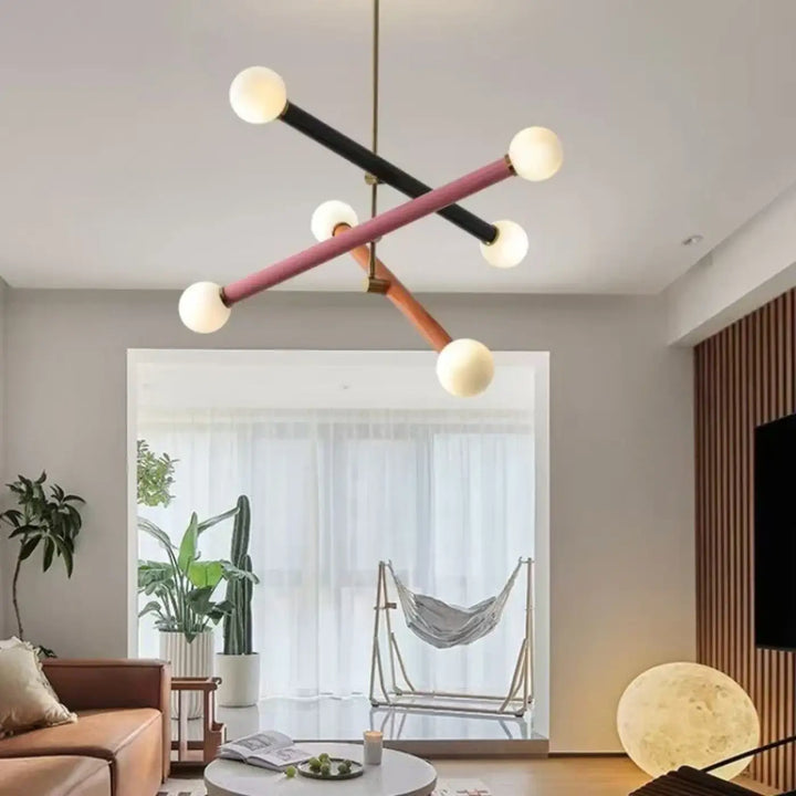 Suspension luminaire tsara avec tiges géométriques noires, roses et bois tenant des ampoules sphériques pour lumière diffuse