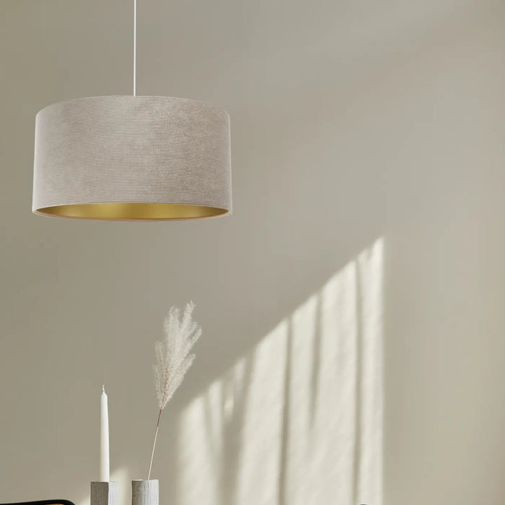 Suspension luminaire cylindrique en tissu beige avec intérieur doré pour un style moderne chic élégant