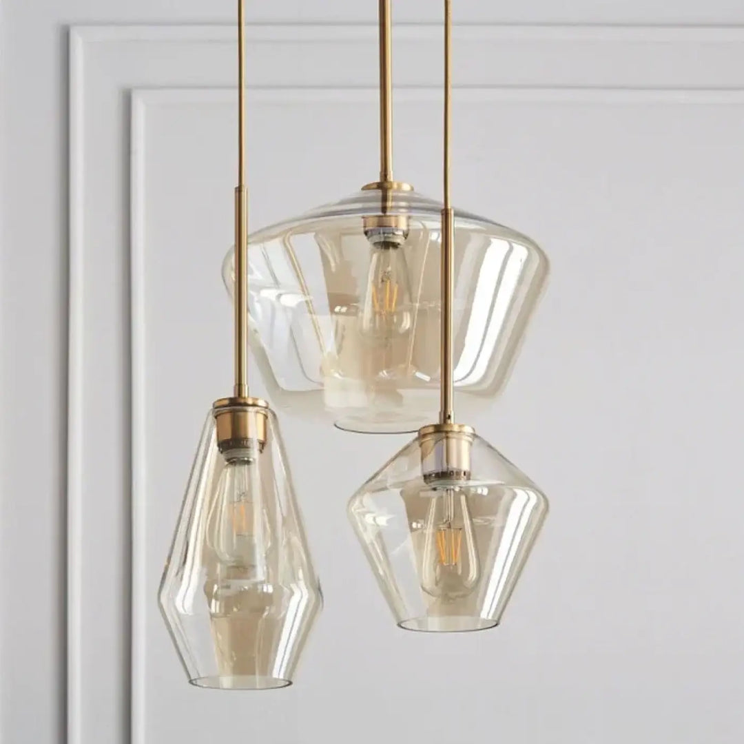 Set de trois suspensions luminaires avec verre transparent et métal doré finition brass pour intérieur moderne