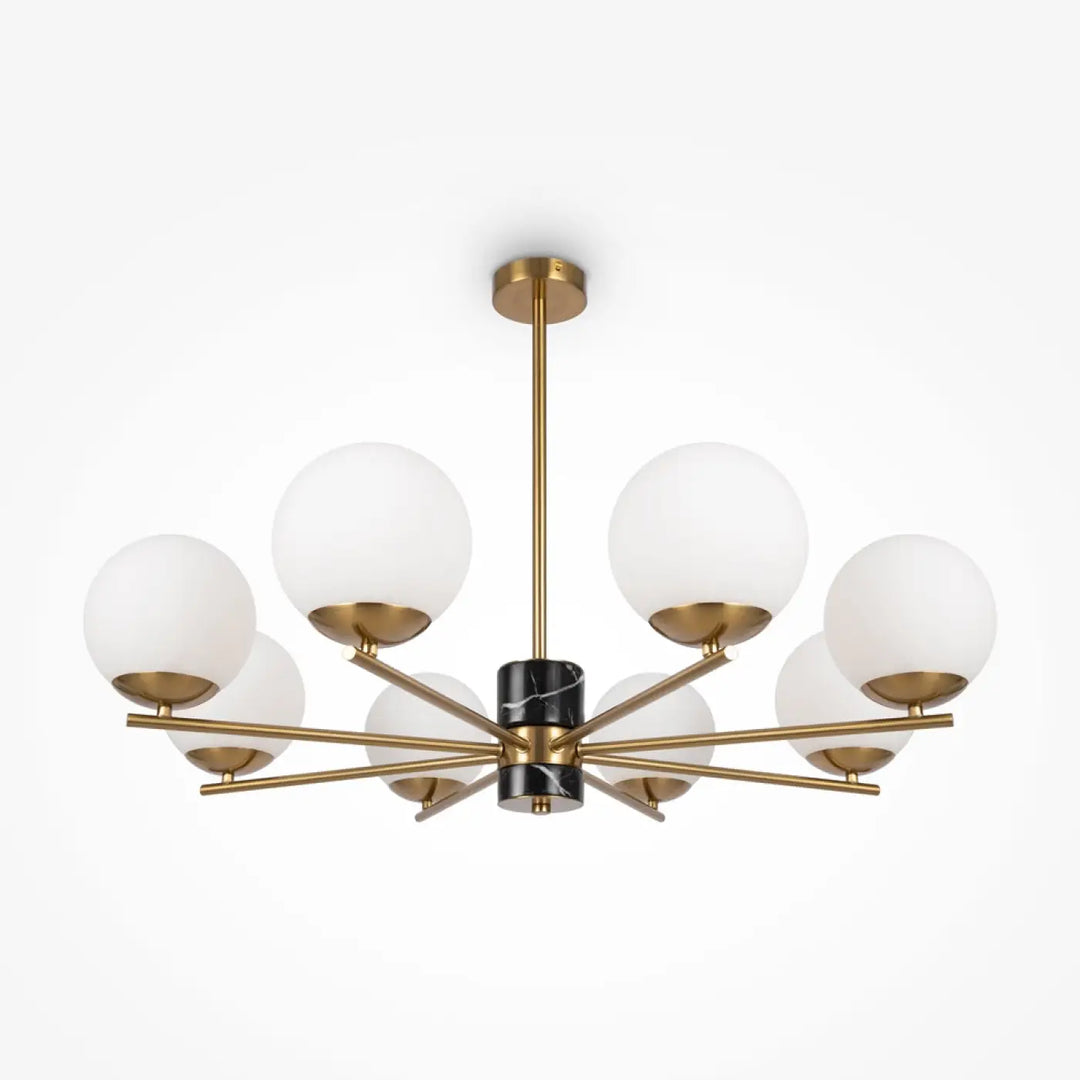 Suspension luminaire marble avec colonne noire en marbre et structure dorée au-dessus d’une pièce avec six globes en verre dépoli